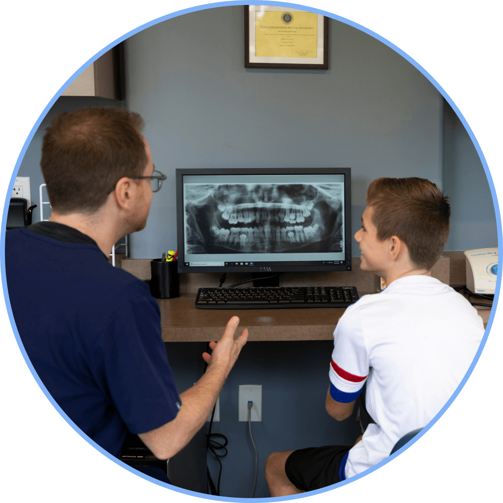 Dentist reviewing a dental X-ray with a young patient