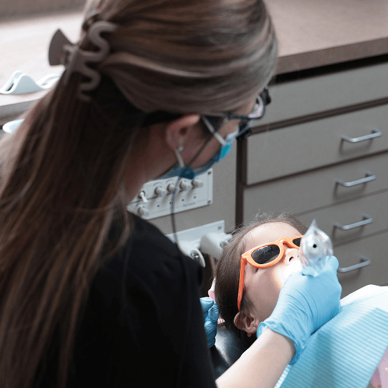 Dentist treating a child during a dental crown visit