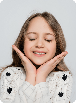 A child smiling and showing healthy teeth